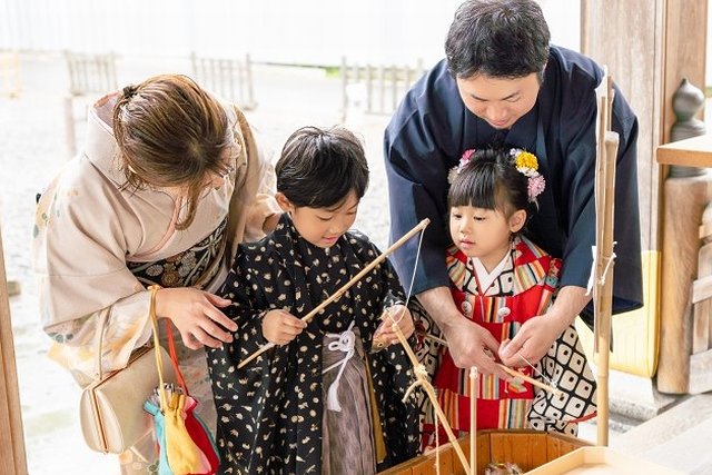 七五三詣でおみくじを引く家族