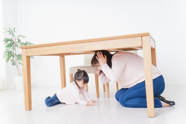 テーブルに下に潜って身を守る親子